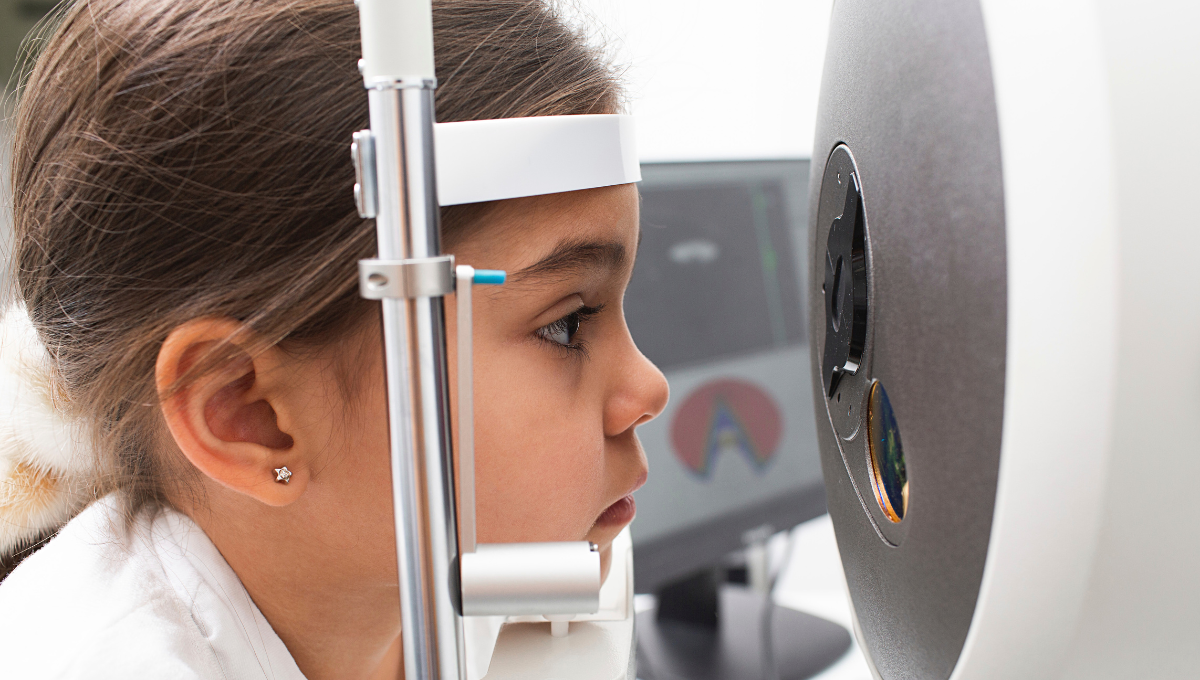 optométriste pédiatrique Petite fille réalisant un examen de la vue avec un appareil ophtalmologique chez l’optométriste
