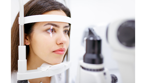 Examen de la vision chez l’optométriste avec un appareil de réfraction pour détecter la myopie ou l’hypermétropie chez une jeune femme